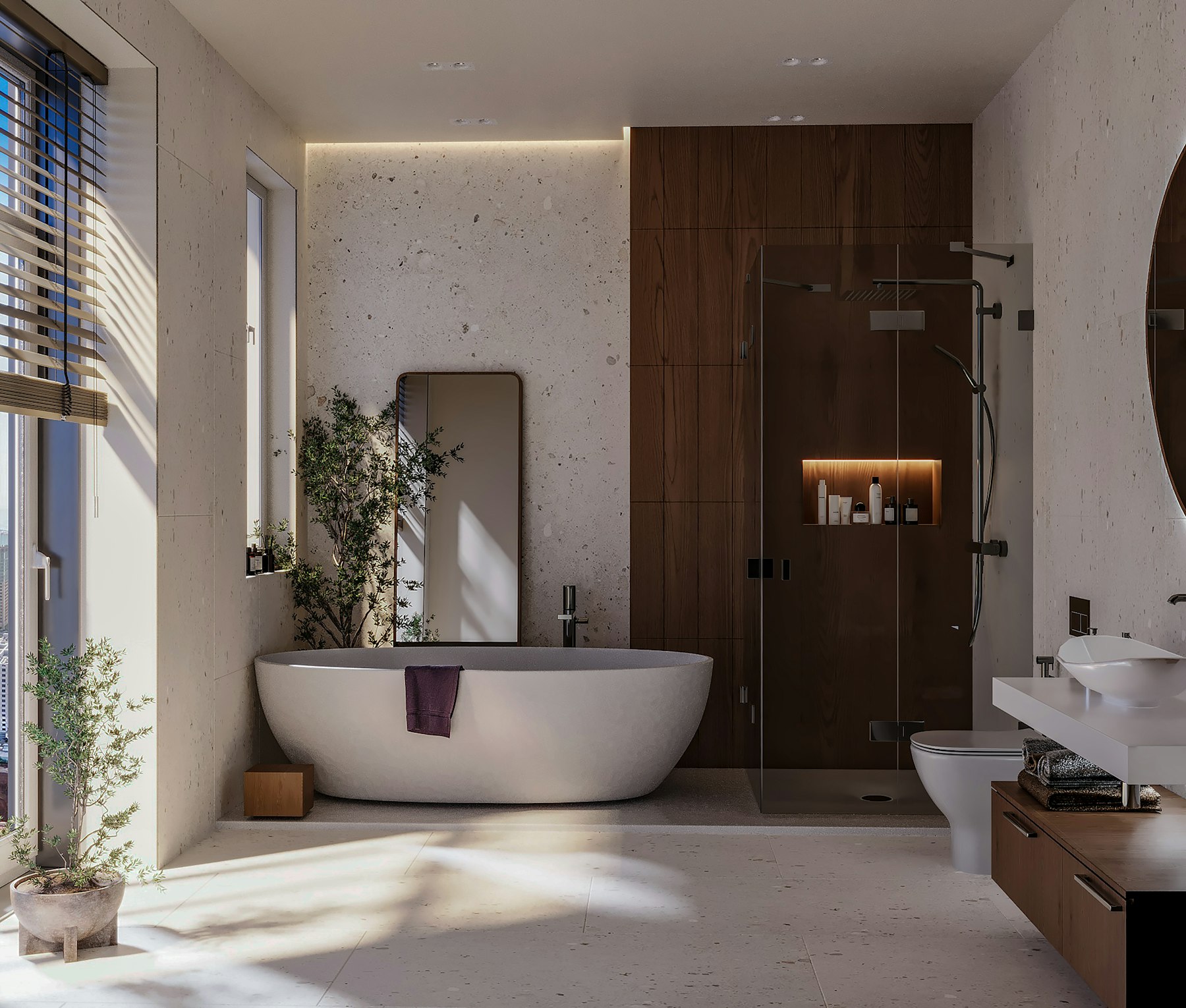 A stone-clad bathroom with a freestanding tub, lit by a concealed cove above the wall and a warm niche in the shower